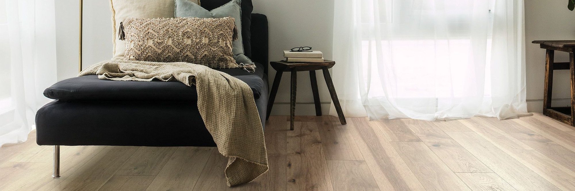 black relaxing couch on brown hardwood floor from Anderson Flooring Centre, Inc. in Winnipeg, MB