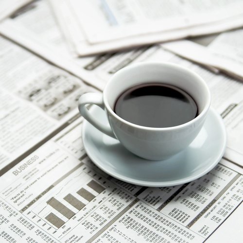 coffee cup on a table full of newspapers in Winnipeg, MB