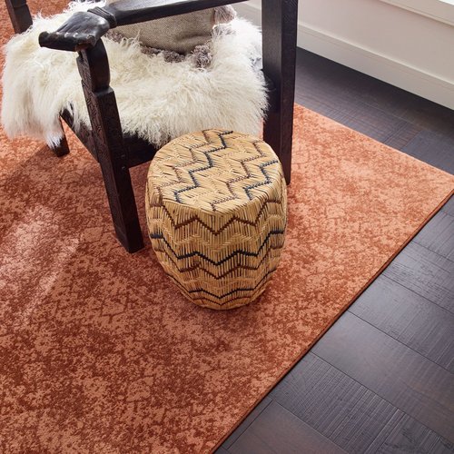 black coffee table and orange rug on a dark brown hardwood floor by Anderson Flooring Centre, Inc. in Winnipeg, MB