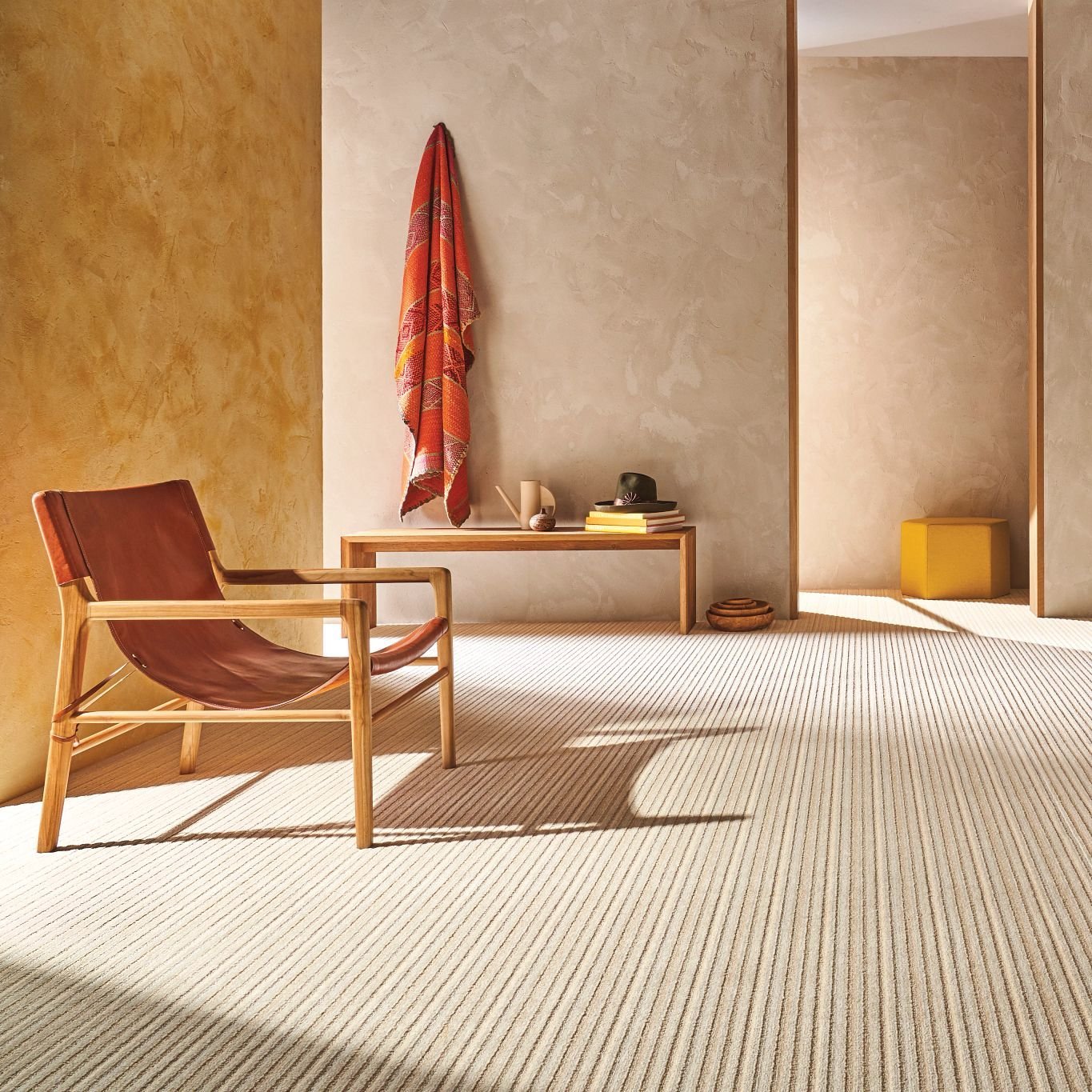 red armchair next to a yellow wall and beige carpet floor from Anderson Flooring Centre, Inc. in Winnipeg, MB